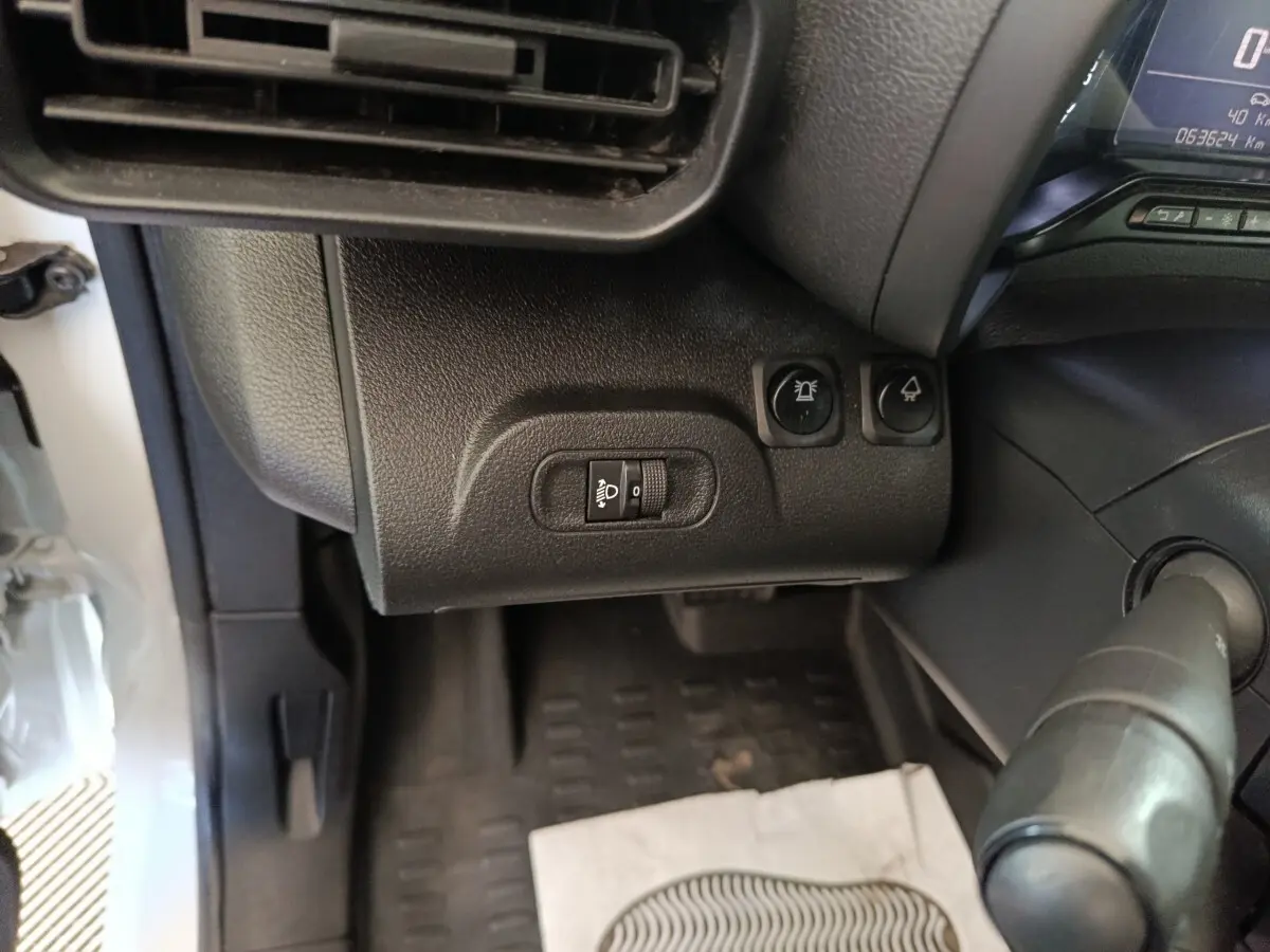 Vue intérieure côté gauche du tableau de bord du Citroën Berlingo blanc 2021, avec commandes d’éclairage et ventilation.