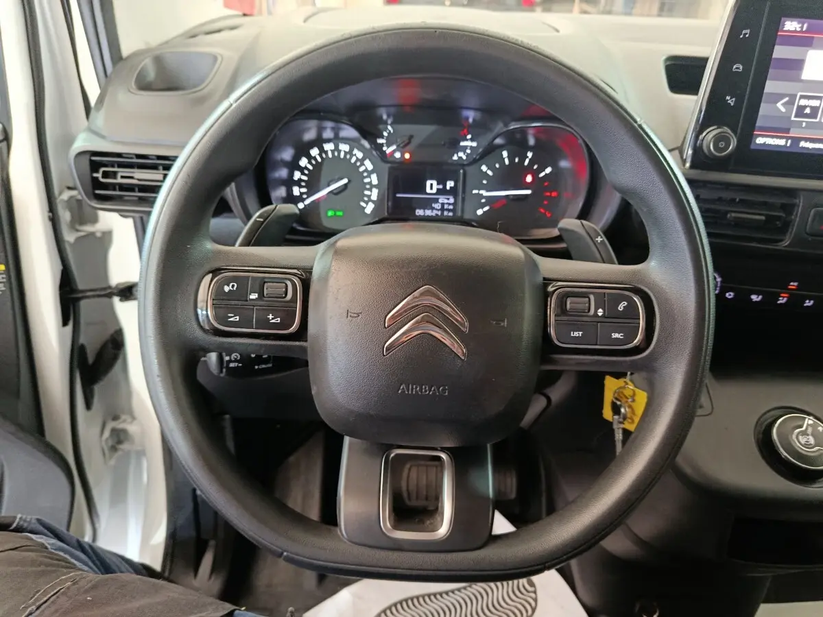 Vue intérieure centrée sur le volant noir du Citroën Berlingo 2021, avec tableau de bord et commandes visibles.