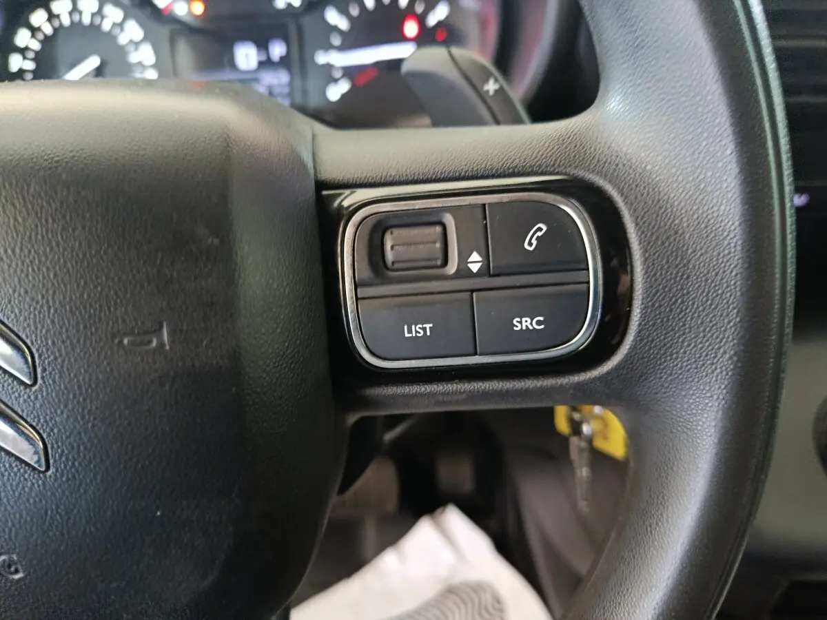 Gros plan sur les commandes au volant côté droit du Citroën Berlingo blanc 2021, avec boutons de gestion audio et appel.
