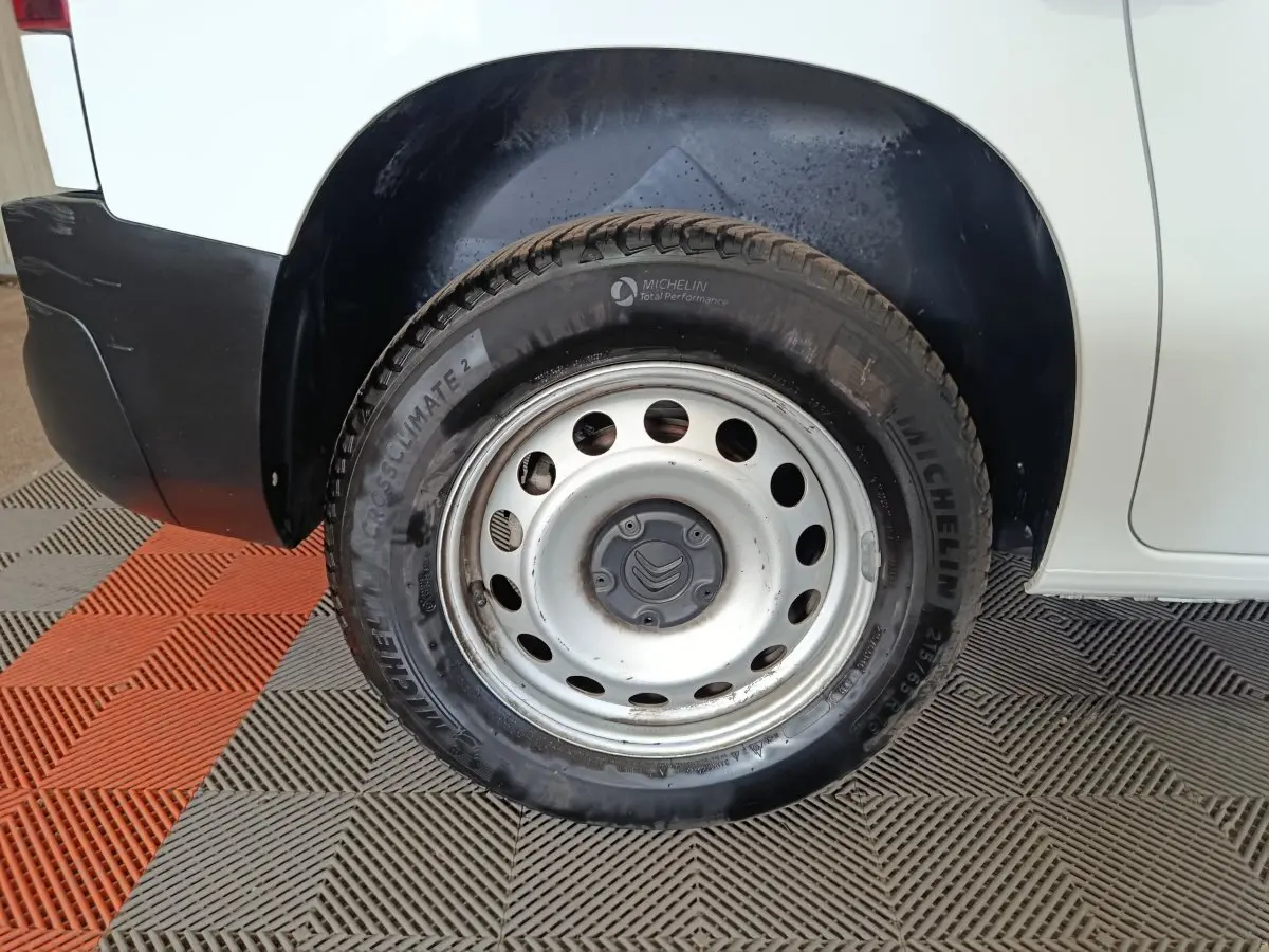 Gros plan sur la roue arrière droite d'un Citroën Berlingo blanc 2021 avec jante acier et pneu Michelin.