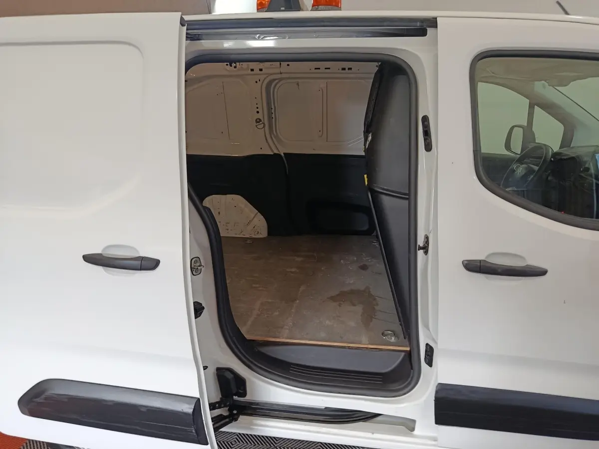 Vue latérale gauche d’un Citroën Berlingo blanc 2021 avec porte coulissante ouverte dévoilant l’espace de chargement vide.