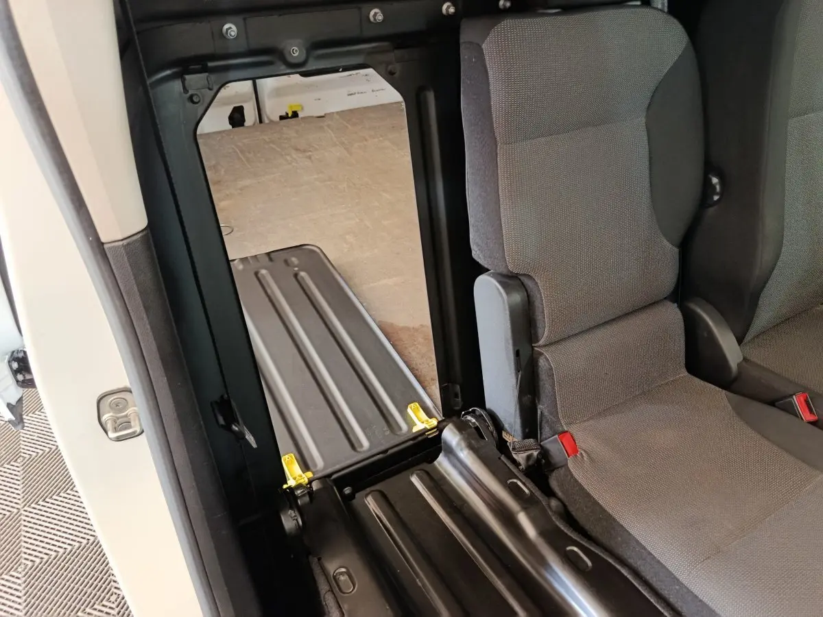 Vue intérieure côté droit du Citroën Berlingo blanc 2021, montrant un siège arrière rabattable et l’espace de chargement.