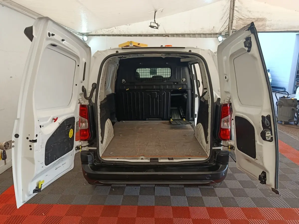 Vue arrière du Citroën Berlingo blanc 2021 avec portes ouvertes montrant l'espace de chargement vide et la cloison de séparation.
