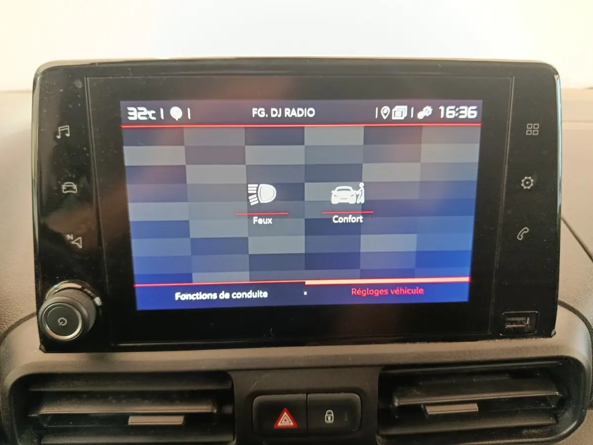 Écran tactile central du tableau de bord du Citroën Berlingo blanc 2021, affichant les réglages des feux et du confort.
