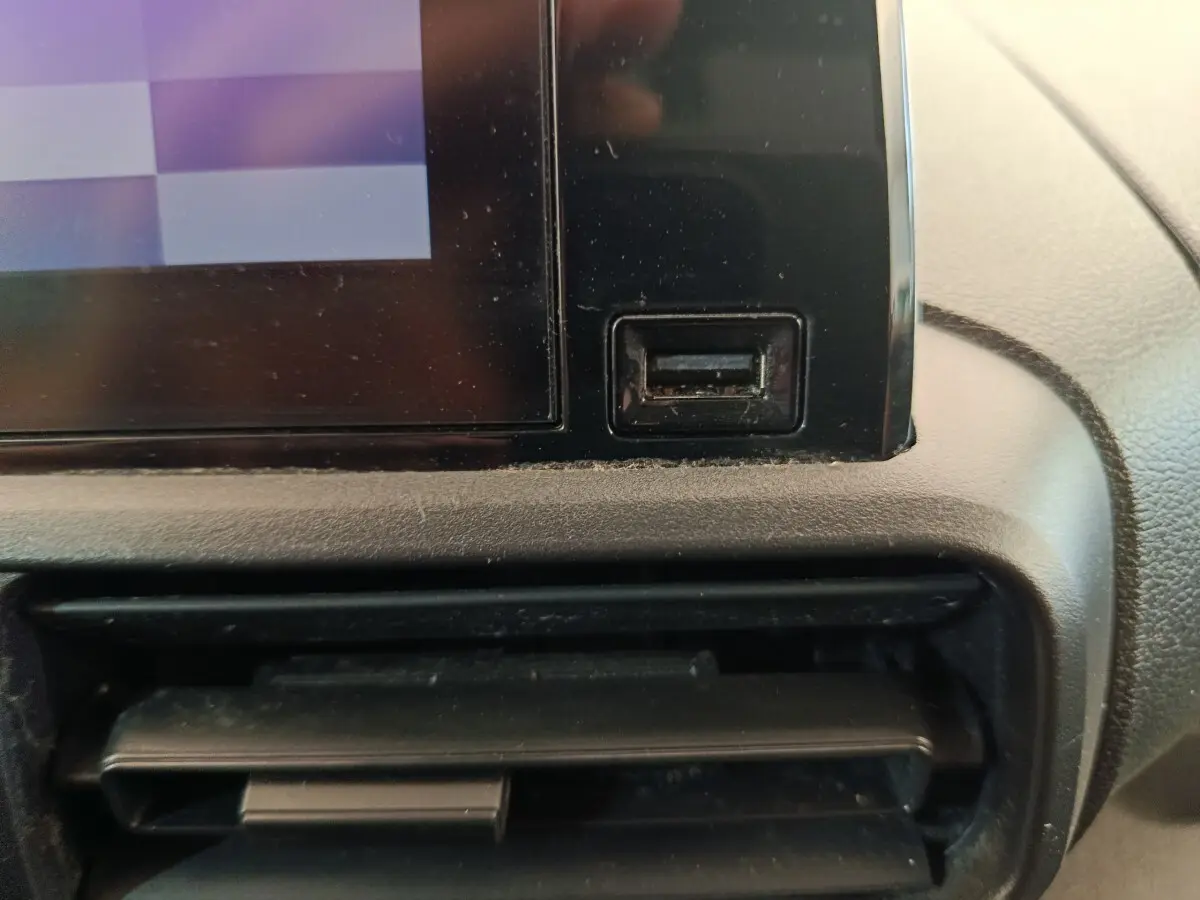 Détail de la console centrale du Citroën Berlingo 2021 montrant un port USB noir et une sortie d'air, intérieur gris.
