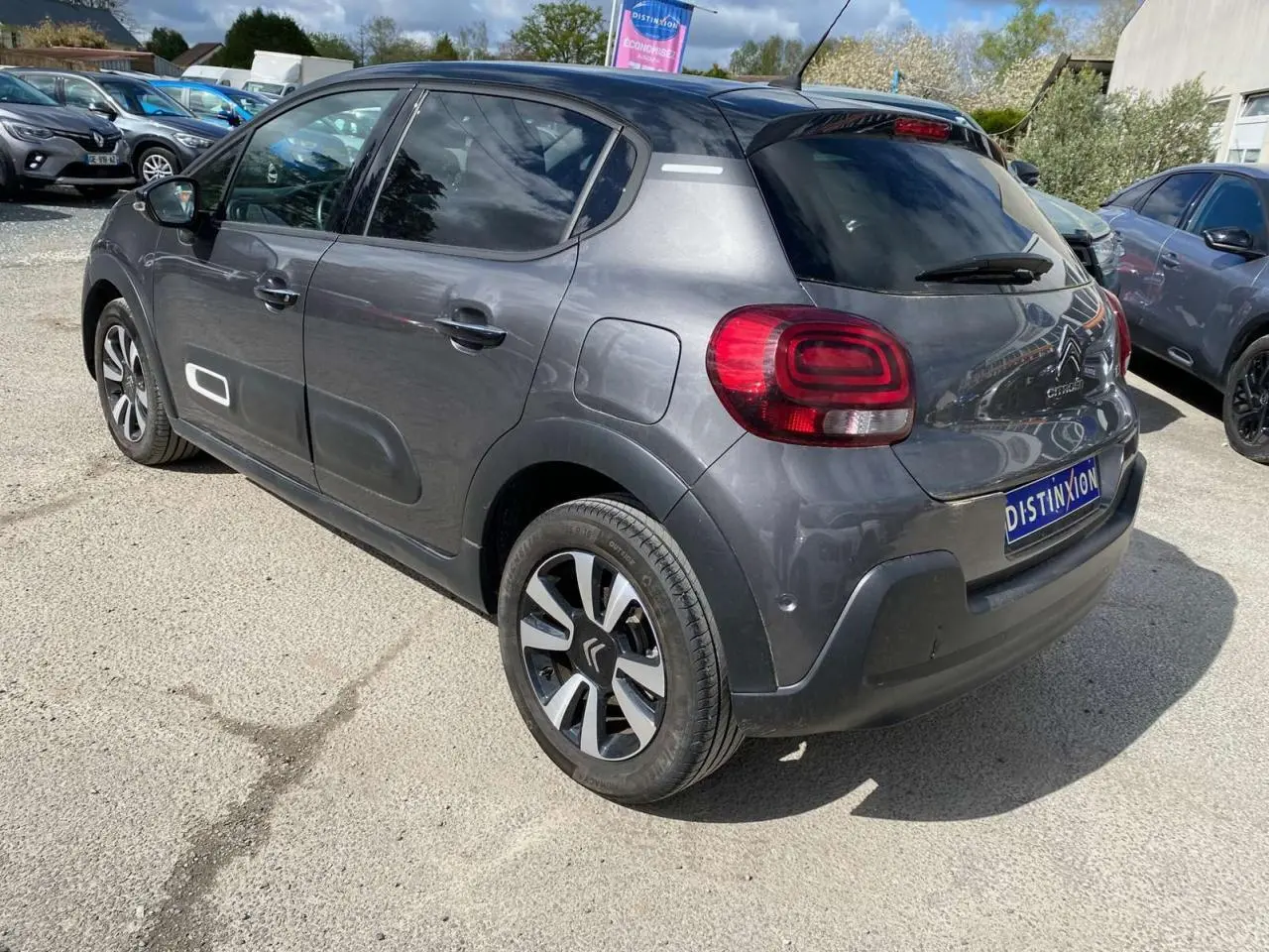 Vue 3/4 arrière droite d'une Citroën C3 gris platinium avec toit noir et jantes alliage diamantées.