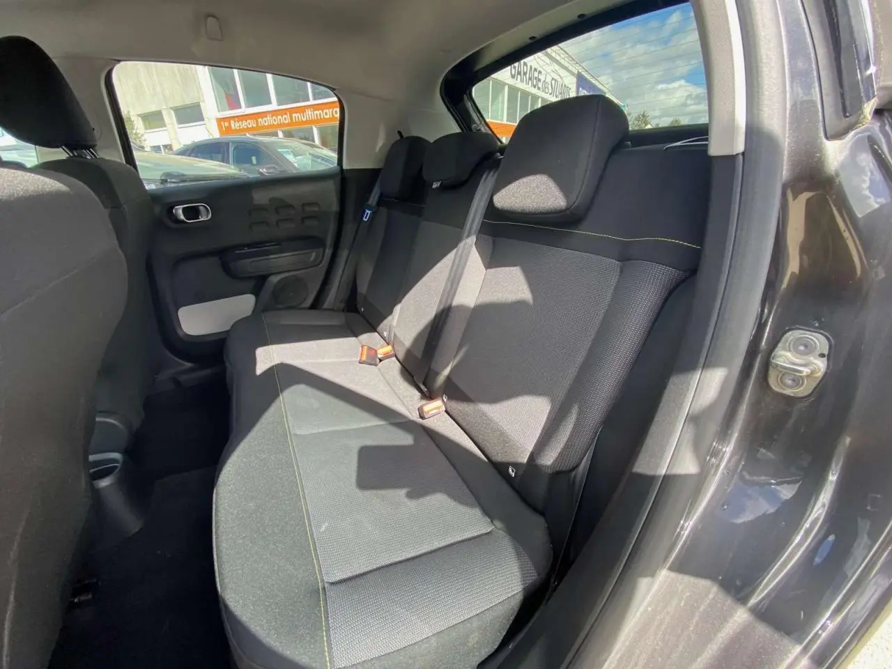 Vue côté droit de la banquette arrière noire avec surpiqûres jaunes d'une Citroën C3 2021 gris platinium.