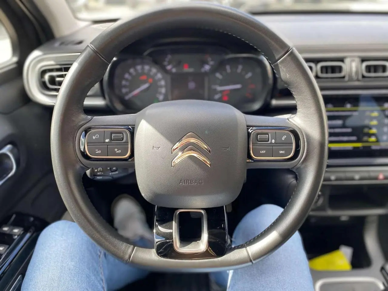 Vue centrée sur le volant noir de la Citroën C3 2021, avec tableau de bord et écran tactile en arrière-plan.