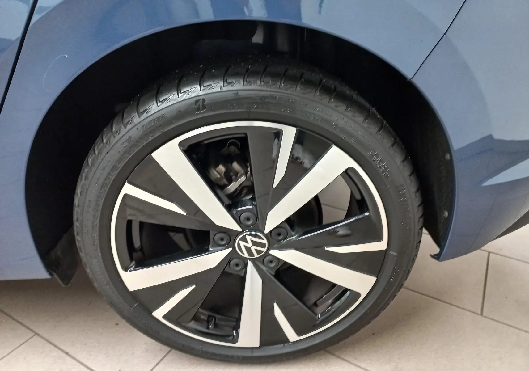 Gros plan sur la jante alliage 18'' Catania noire et argentée d'une Volkswagen Golf Bleu Anemone, côté arrière droit.