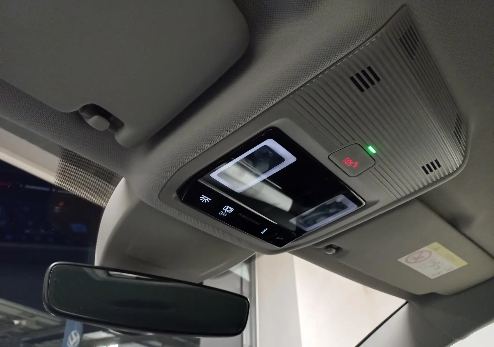 Plafonnier intérieur avec commandes lumineuses et bouton SOS éclairé dans une Volkswagen Golf Bleu Anemone 2025.