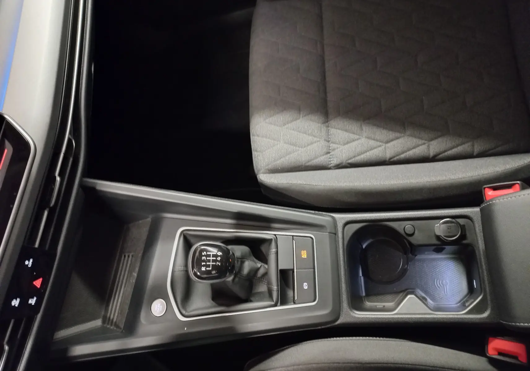 Vue plongeante sur la console centrale de la Volkswagen Golf 1.5 TSI 116 BVM6 avec levier de vitesse manuel et porte-gobelets.