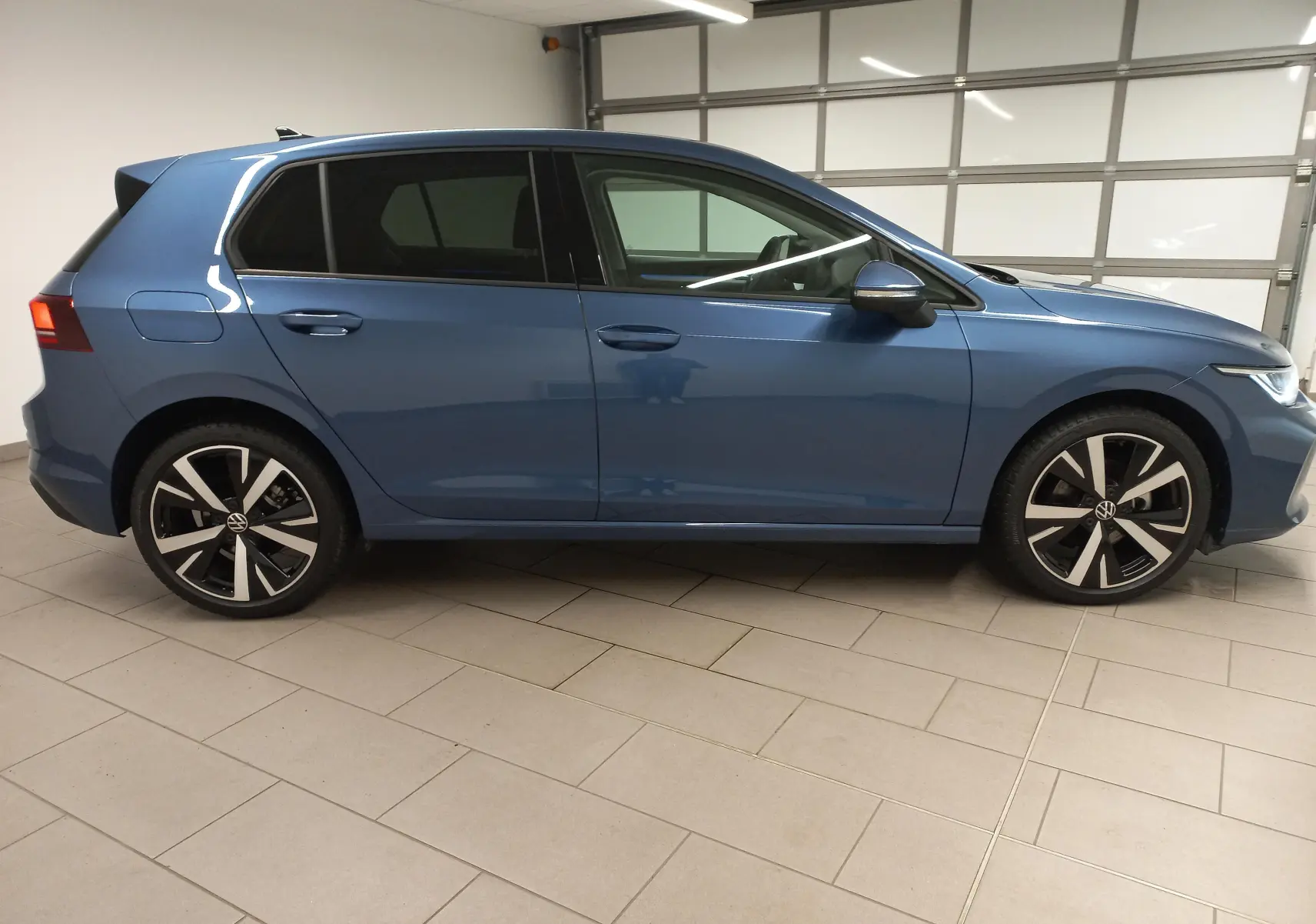 Volkswagen Golf 1.5 TSI 2025 en bleu Anemone, vue profil côté gauche avec jantes alliage 18 pouces Catania.