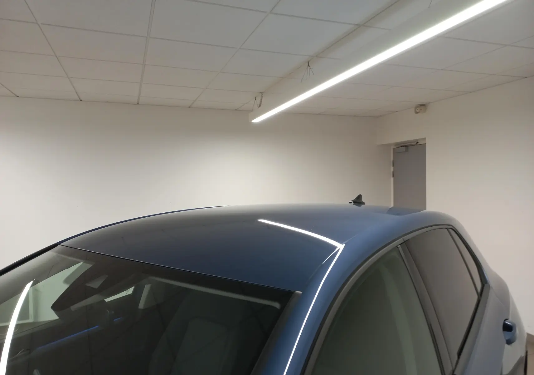 Vue en plongée du toit et des vitres teintées d'une Volkswagen Golf 1.5 TSI Bleu Anemone dans un intérieur blanc.