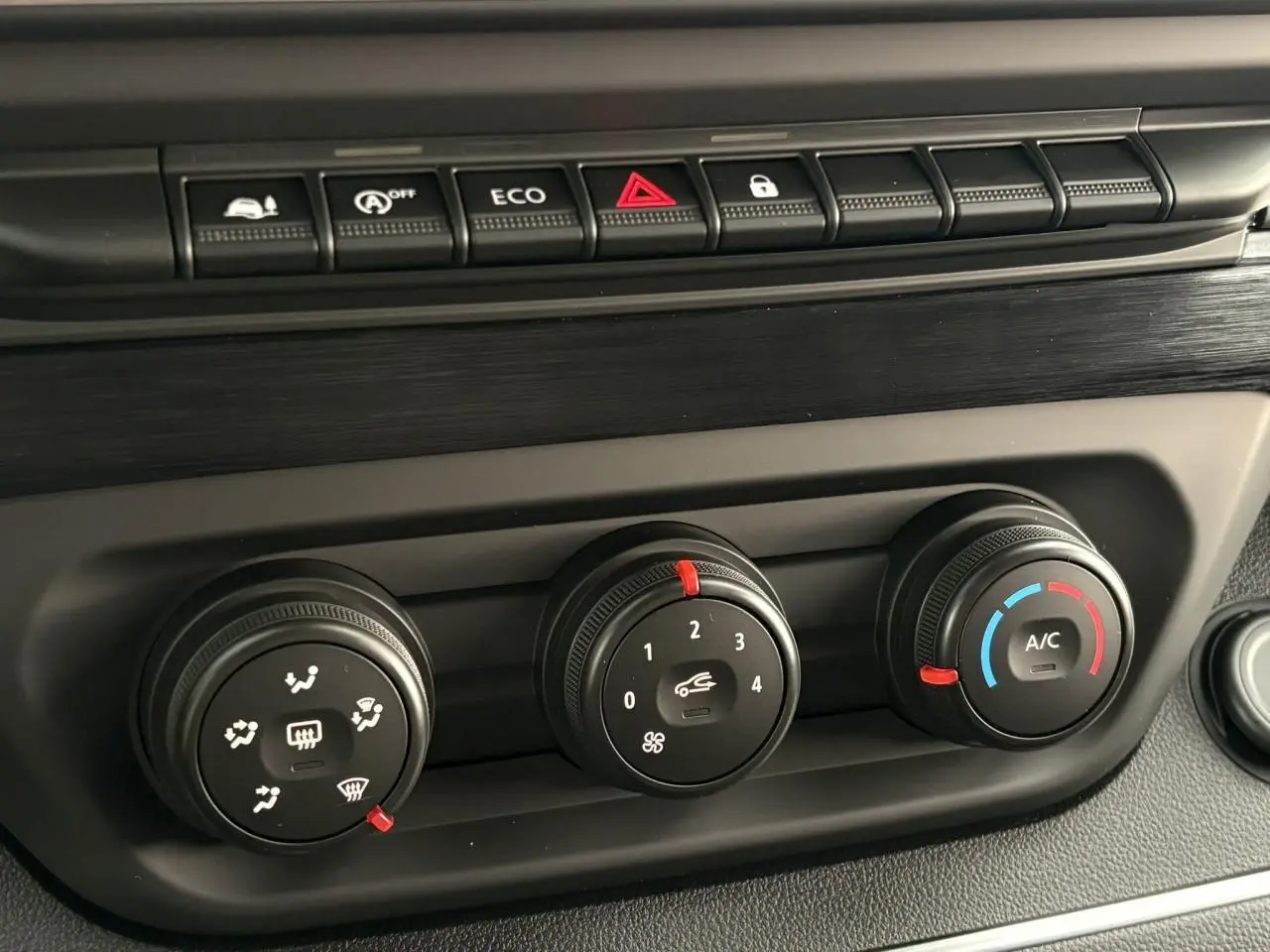 Détail des commandes de climatisation et boutons de fonction sur le tableau de bord du Renault Trafic Fourgon blanc.