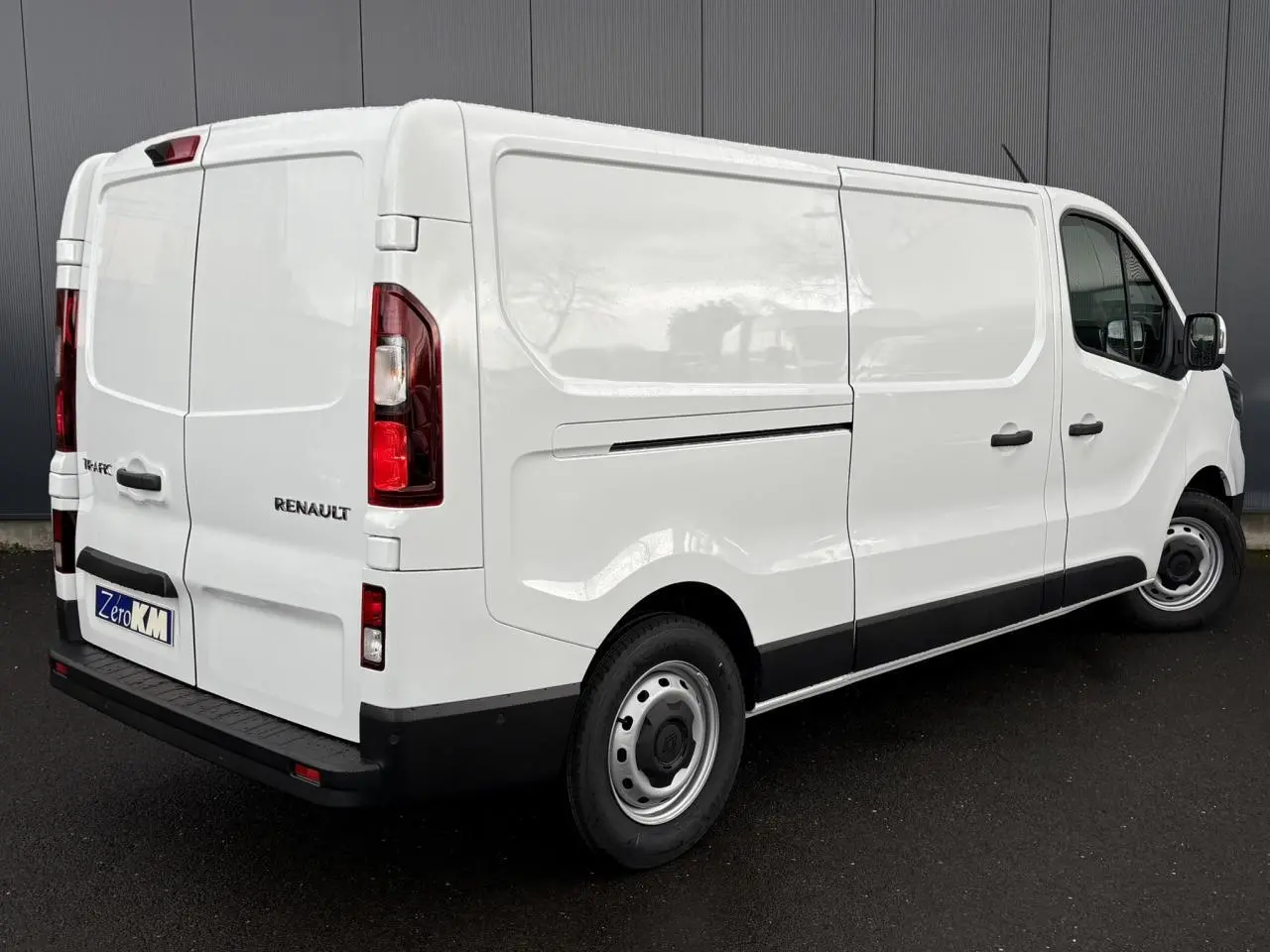 Vue 3/4 arrière droite du Renault Trafic Fourgon blanc Glacier avec portes arrière tôlées et porte latérale coulissante.