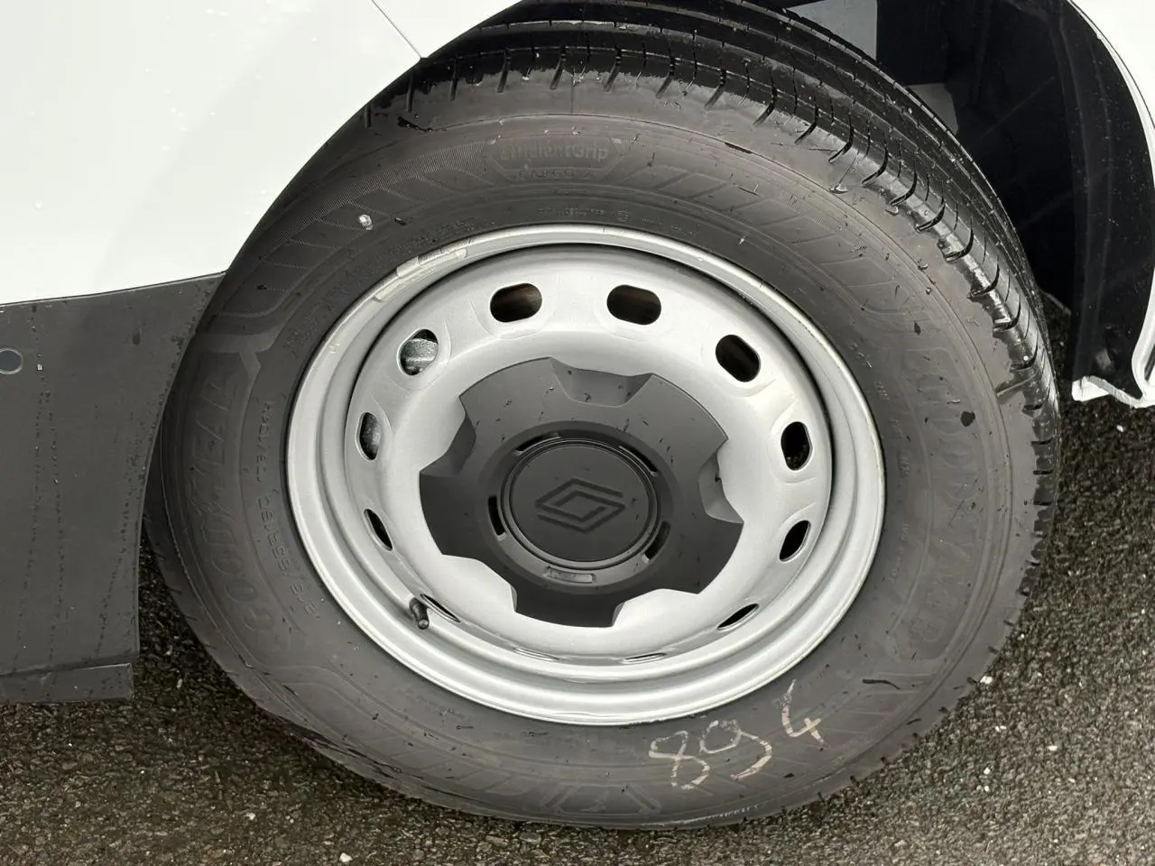 Gros plan sur la roue avant droite du Renault Trafic Fourgon blanc Glacier avec jante acier et logo Renault central.