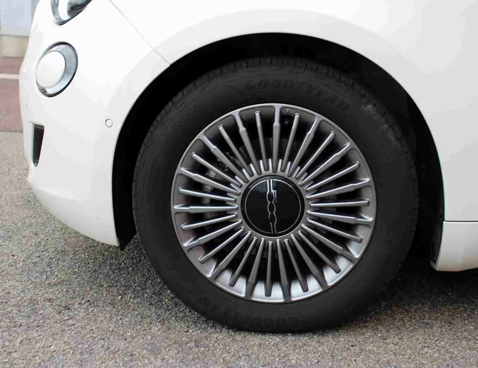 Gros plan sur la jante avant droite argentée au design rayonné d'une FIAT 500 électrique blanche de 2023.