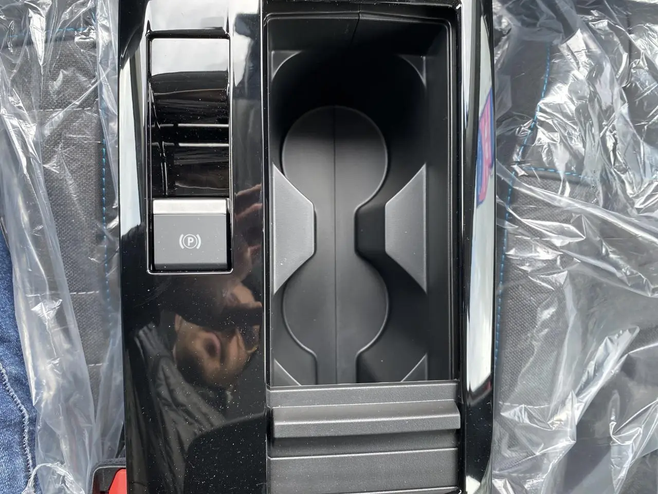 Gros plan sur la console centrale noire brillante avec frein de stationnement électrique dans une Citroën C4 Rouge Elixir 2023