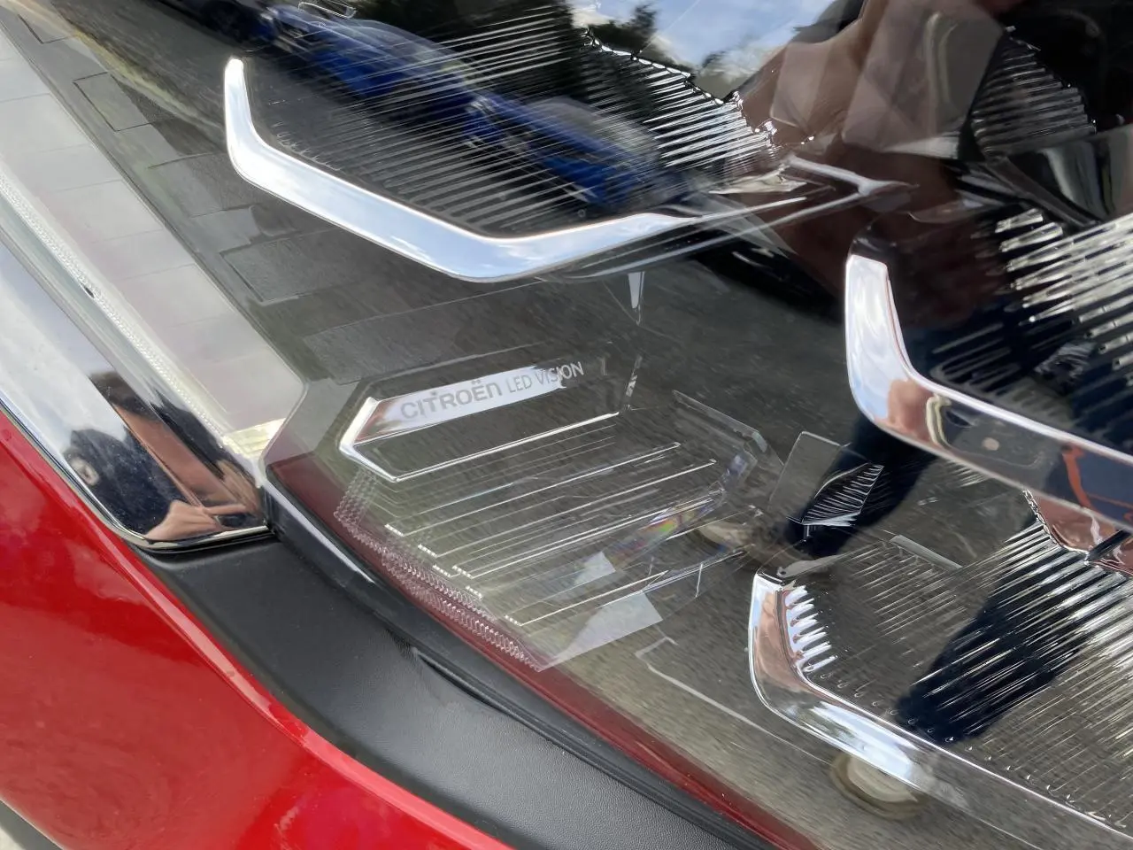 Gros plan sur le phare avant droit rouge Elixir de la Citroën C4 2023 avec signature lumineuse LED distinctive.