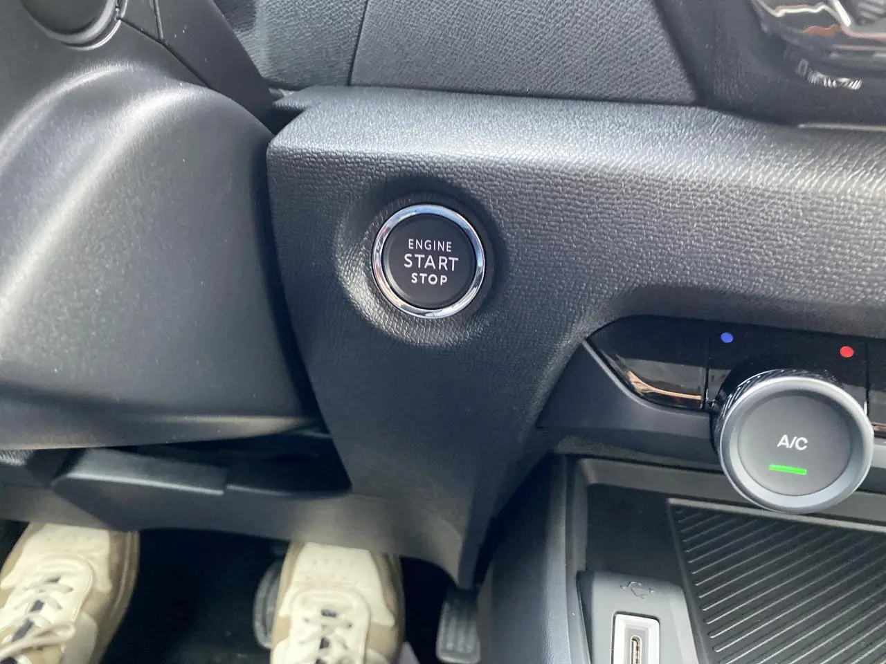 Bouton start/stop moteur et commande de climatisation sur tableau de bord d'une Citroën C4 2023 vue côté conducteur.