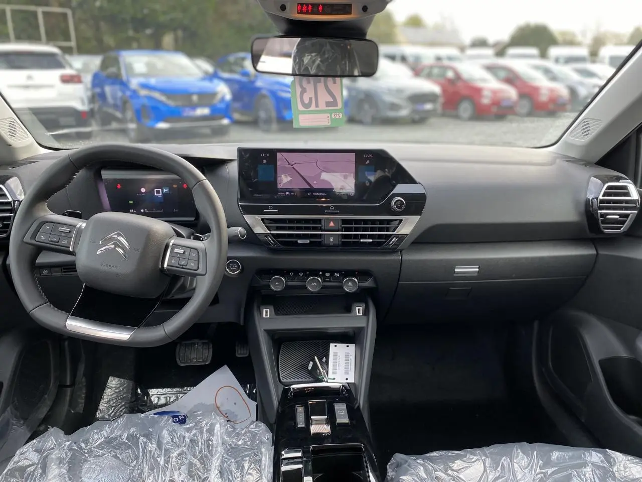 Vue intérieure avant du tableau de bord et volant Citroën C4 2023, avec écran tactile et commandes au volant.