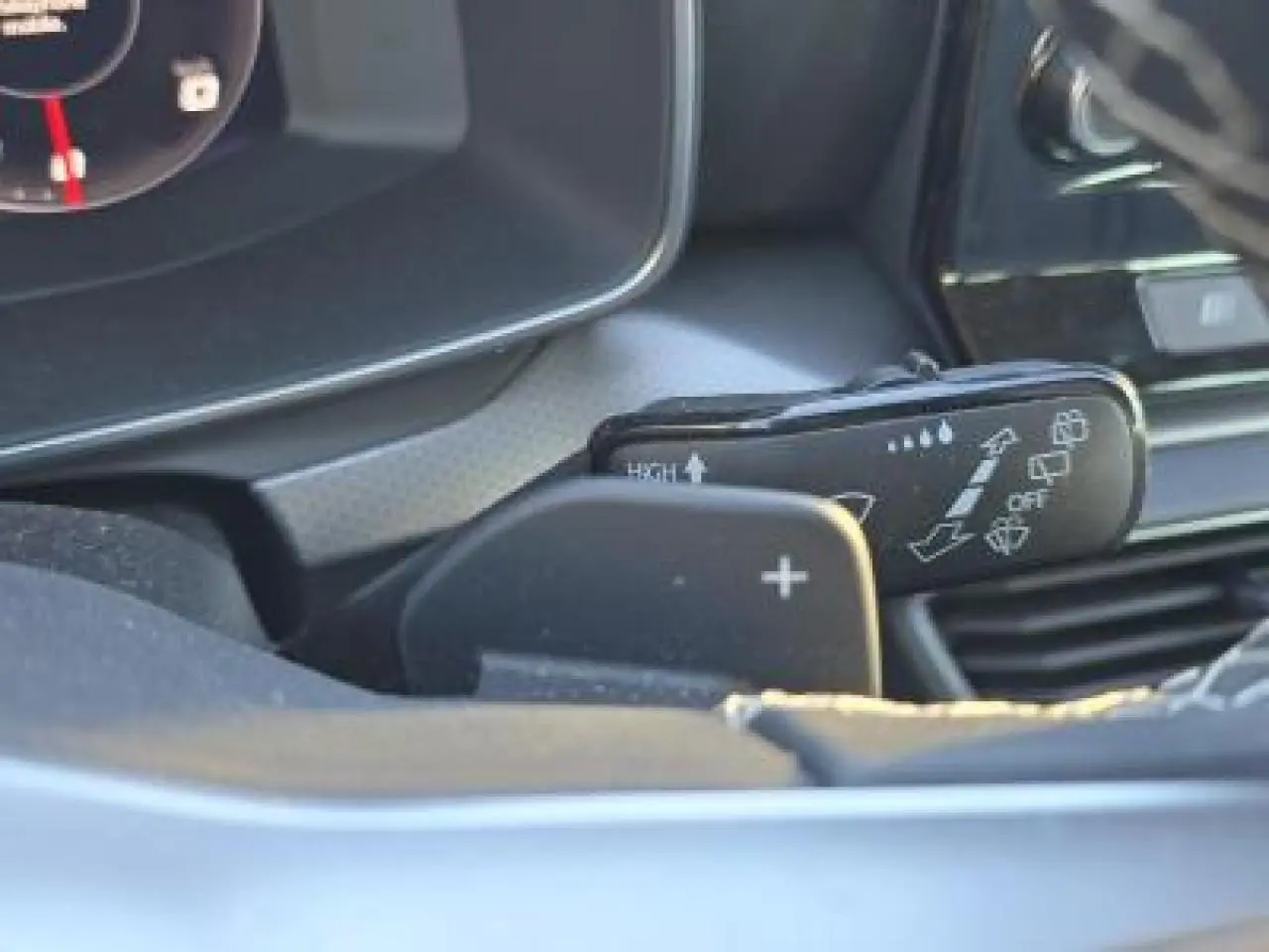 Gros plan sur la commande des essuie-glaces et la palette de changement de vitesse côté gauche du tableau de bord d'une SEAT Leon blanche.