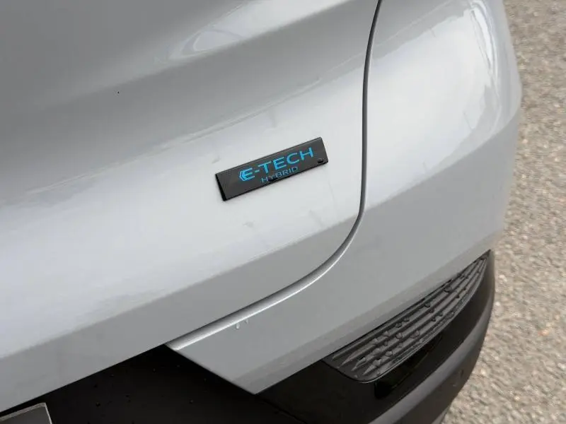 Gros plan sur l'arrière droit du Renault Captur 2026 gris Rafale avec badge E-Tech Hybrid bleu.