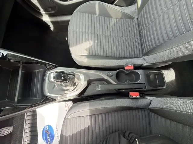 Vue intérieure plongeante sur la console centrale et les sièges avant gris foncé de la Peugeot 208 100CH S&S Active 2024.