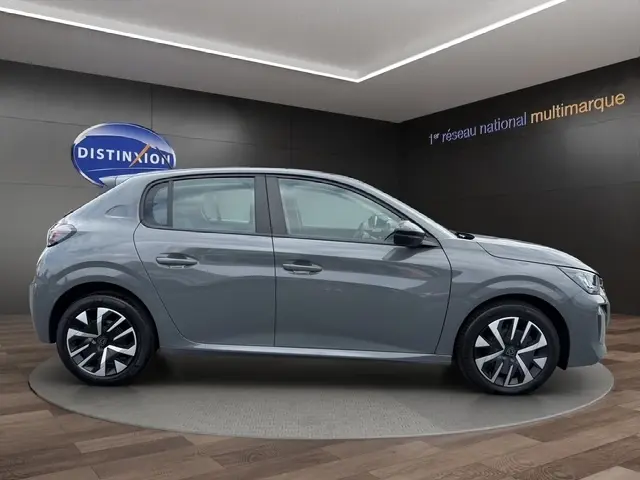 Profil latéral droit d'une Peugeot 208 gris foncé 2024, avec jantes alliage et poignées de porte ton caisse.