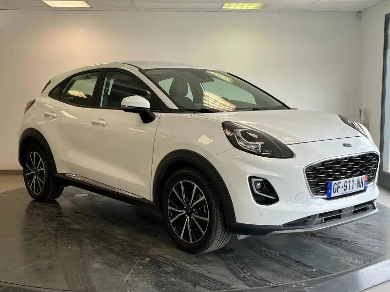 Ford Puma blanc glacier vu de 3/4 avant droit, avec jantes alu noires et calandre imposante noire.