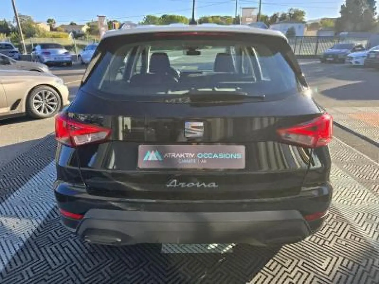 Vue arrière d'un SEAT Arona noir minuit avec toit contrasté et feux arrière rouges en extérieur.