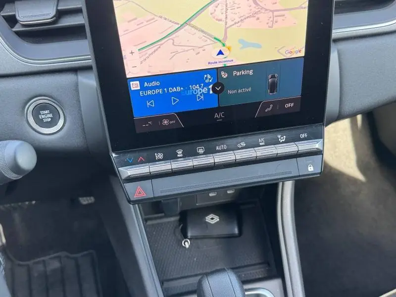 Détail de la console centrale du Renault Captur 2025 rouge, avec écran tactile affichant GPS et commandes climatisation.