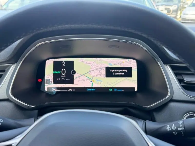 Vue intérieure du tableau de bord numérique du Renault Captur 2025 affichant la navigation et alertes de parking.