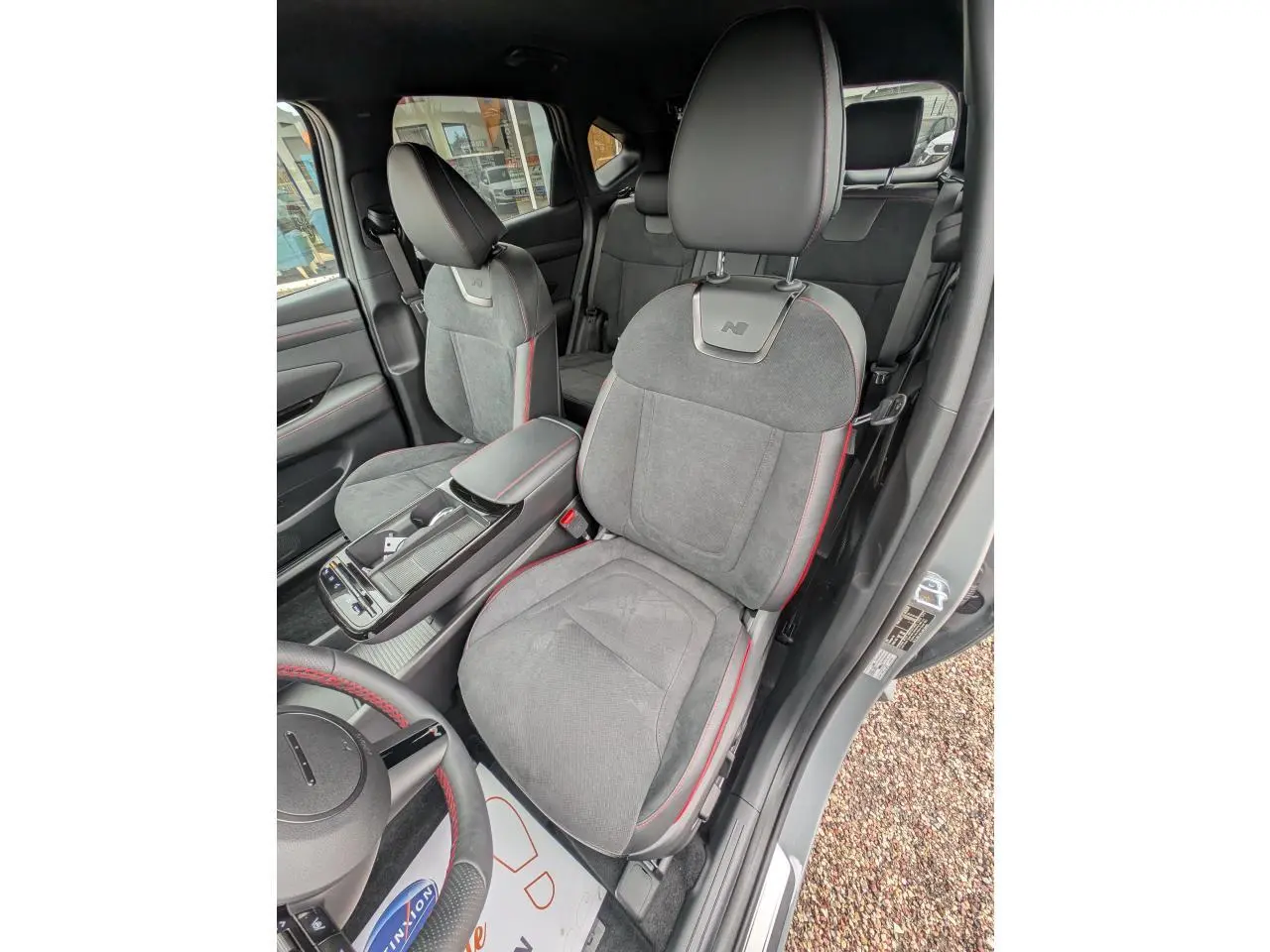Vue intérieure côté conducteur du Hyundai Tucson gris, sièges N Line en cuir/alcantara avec surpiqûres rouges.