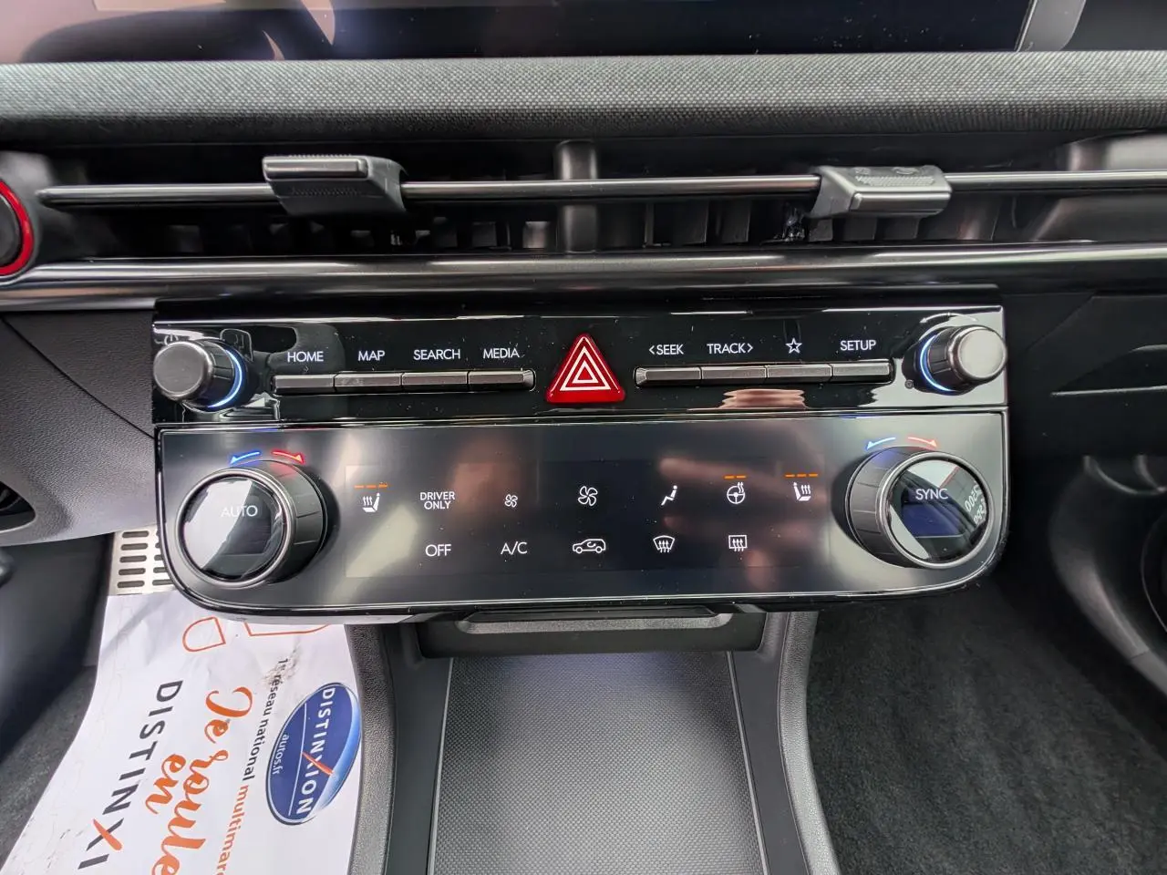 Vue rapprochée du tableau de bord noir du Hyundai Tucson gris, mettant en valeur la console centrale avec commandes climatisation et multimédia.