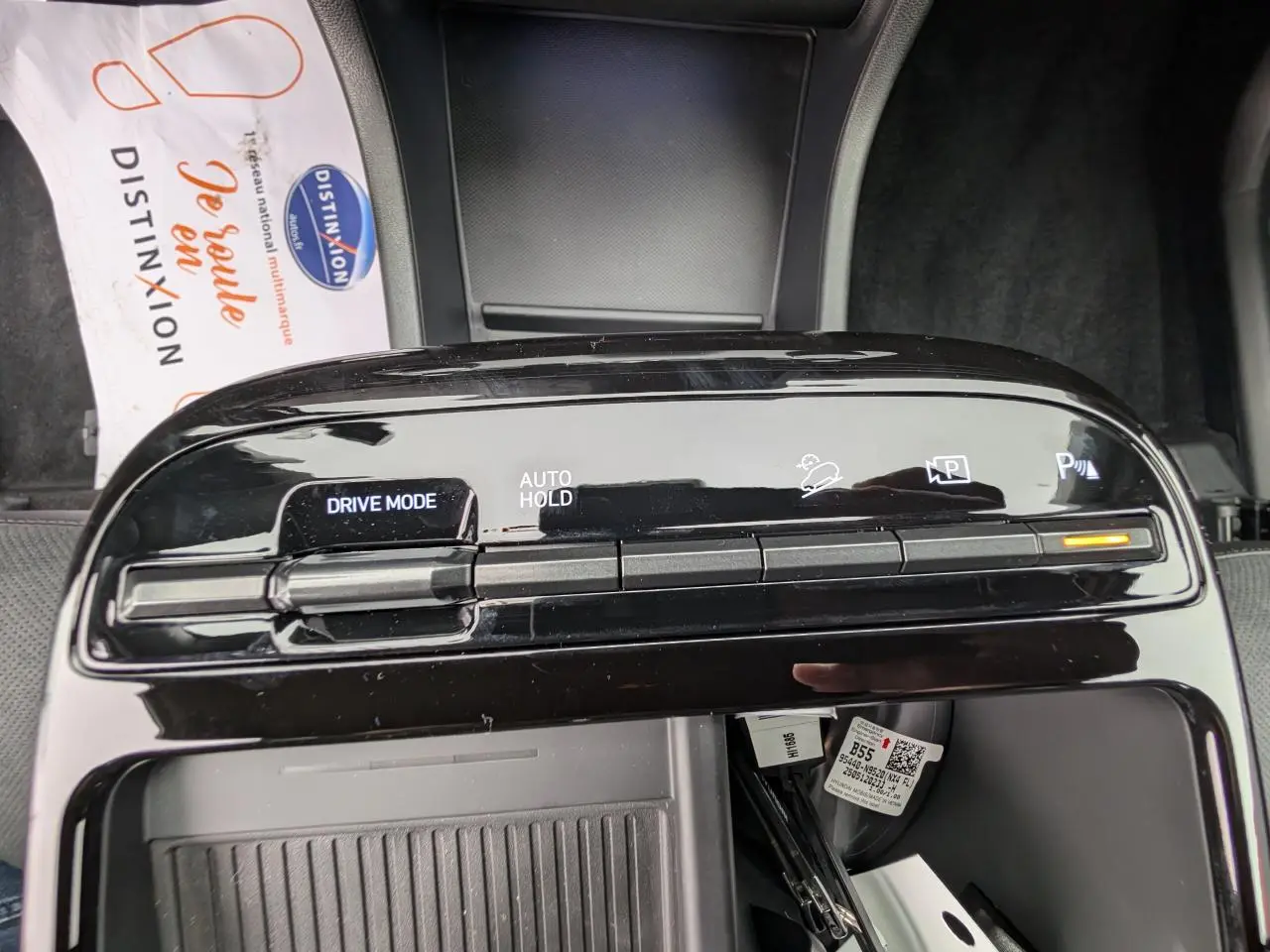 Vue rapprochée de la console centrale noire brillante du Hyundai Tucson gris, avec commandes Drive Mode et Auto Hold.