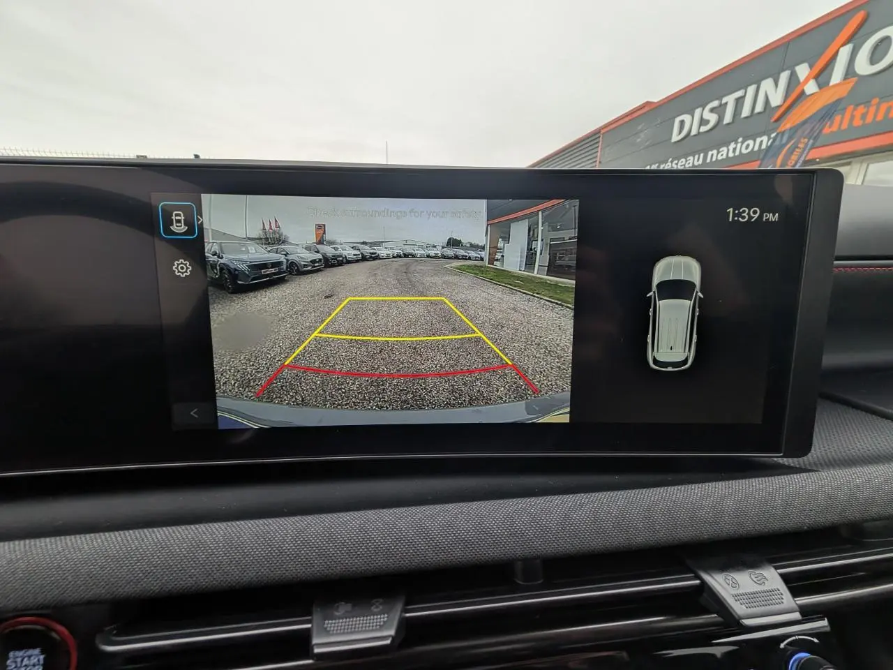 Écran intérieur montrant la caméra de recul du Hyundai Tucson gris, avec lignes de guidage actives.