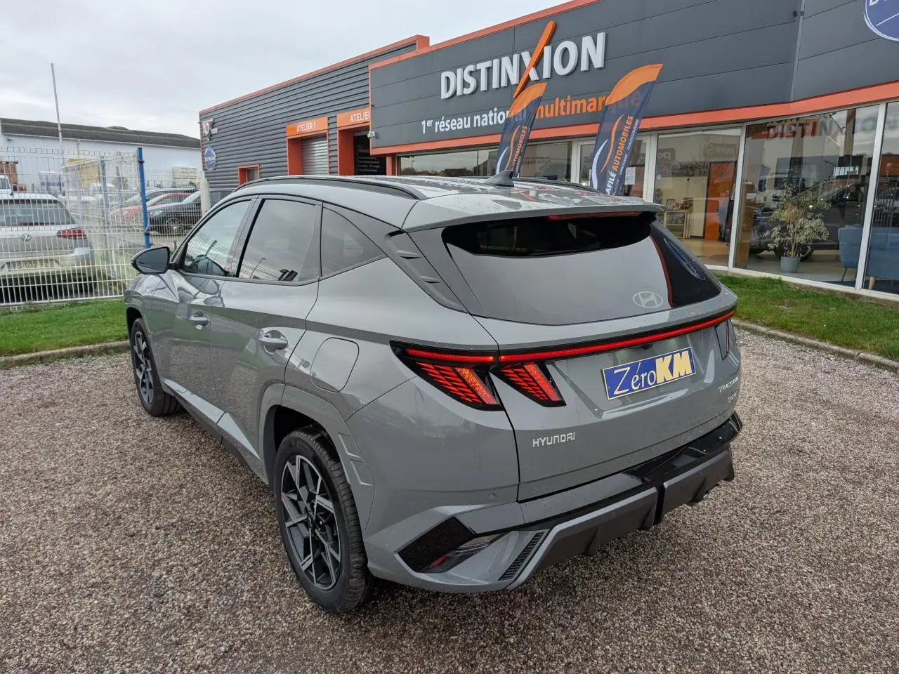 Vue 3/4 arrière droite d’un Hyundai Tucson gris métallisé avec feux arrière LED et jantes alliage 19 pouces N Line.