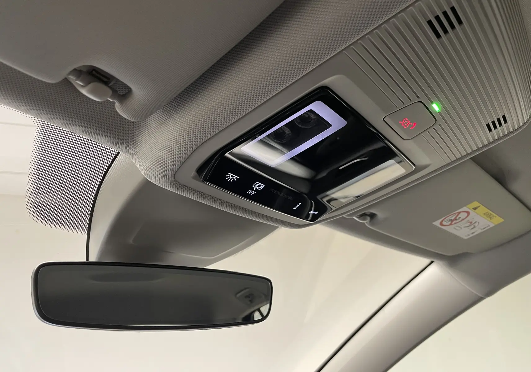 Plafonnier intérieur avec commandes d'éclairage et bouton SOS éclairé, vue depuis le siège conducteur d'une Volkswagen Golf 2023.