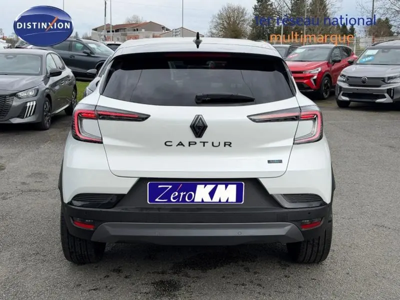 Vue arrière d'un Renault Captur blanc nacré avec toit noir, feux LED et logo central bien visible.