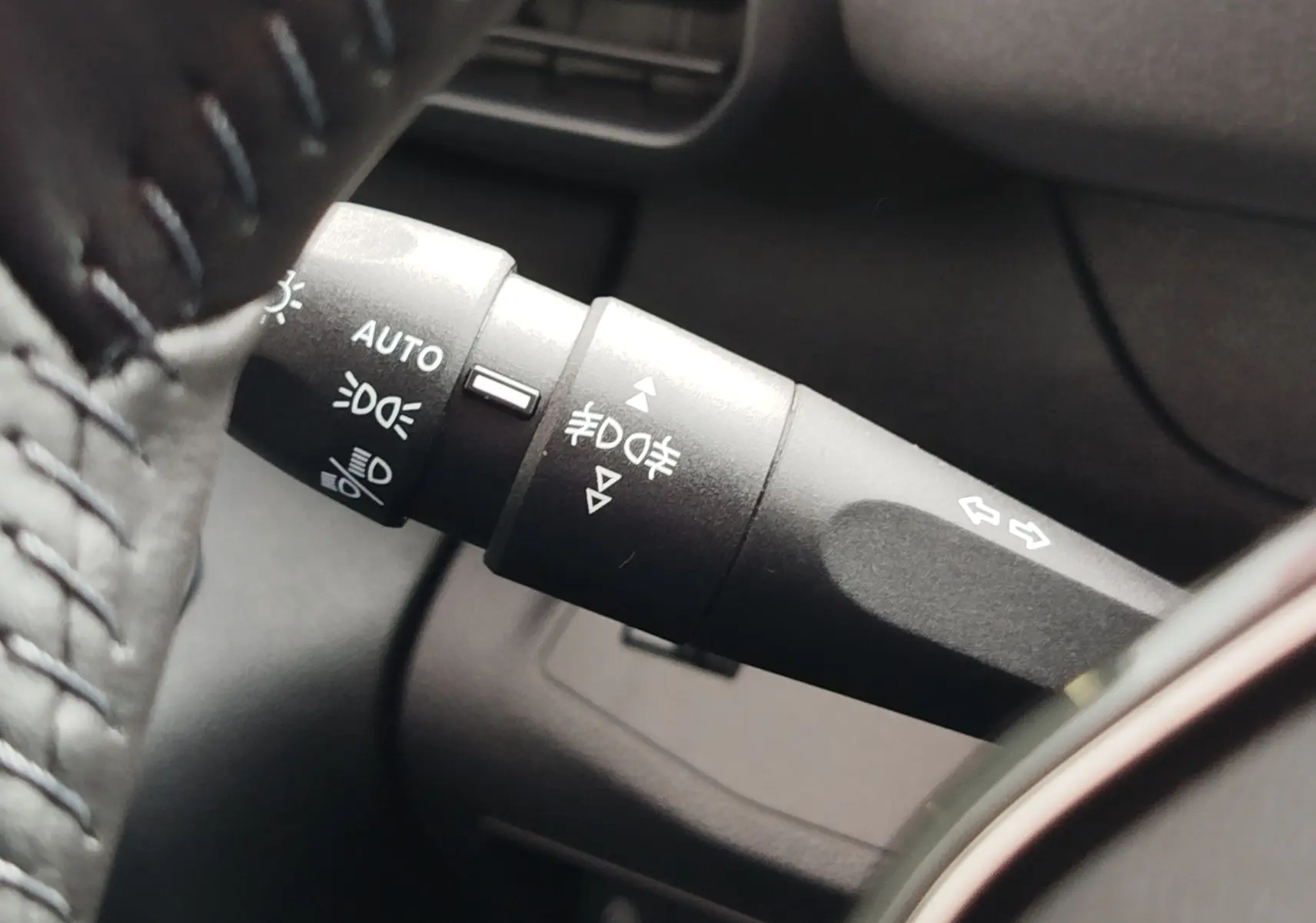 Gros plan sur la manette de commande des feux et clignotants du Peugeot Rifter noir Perla Nera, version 2026.