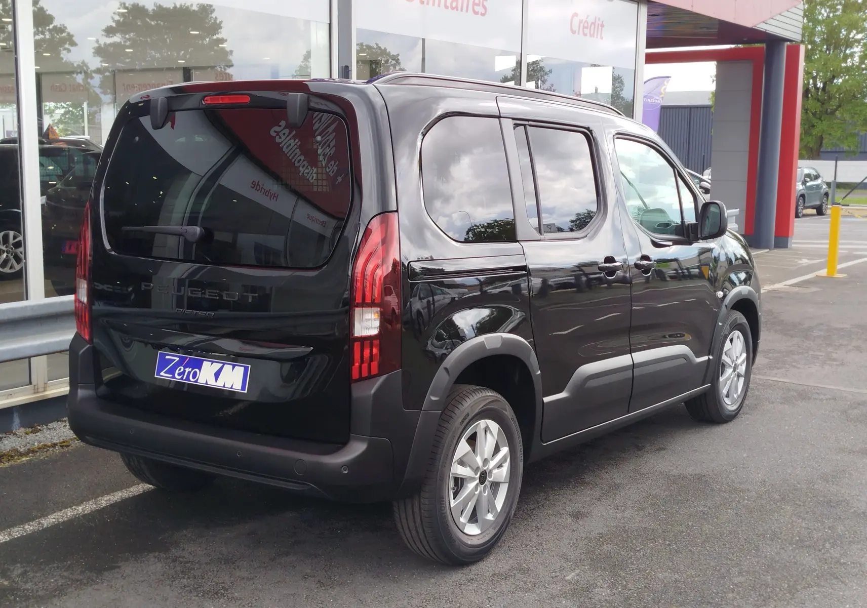 Peugeot Rifter noir Perla Nera vu en 3/4 arrière droit, avec vitres teintées et jantes alliage 16 pouces.