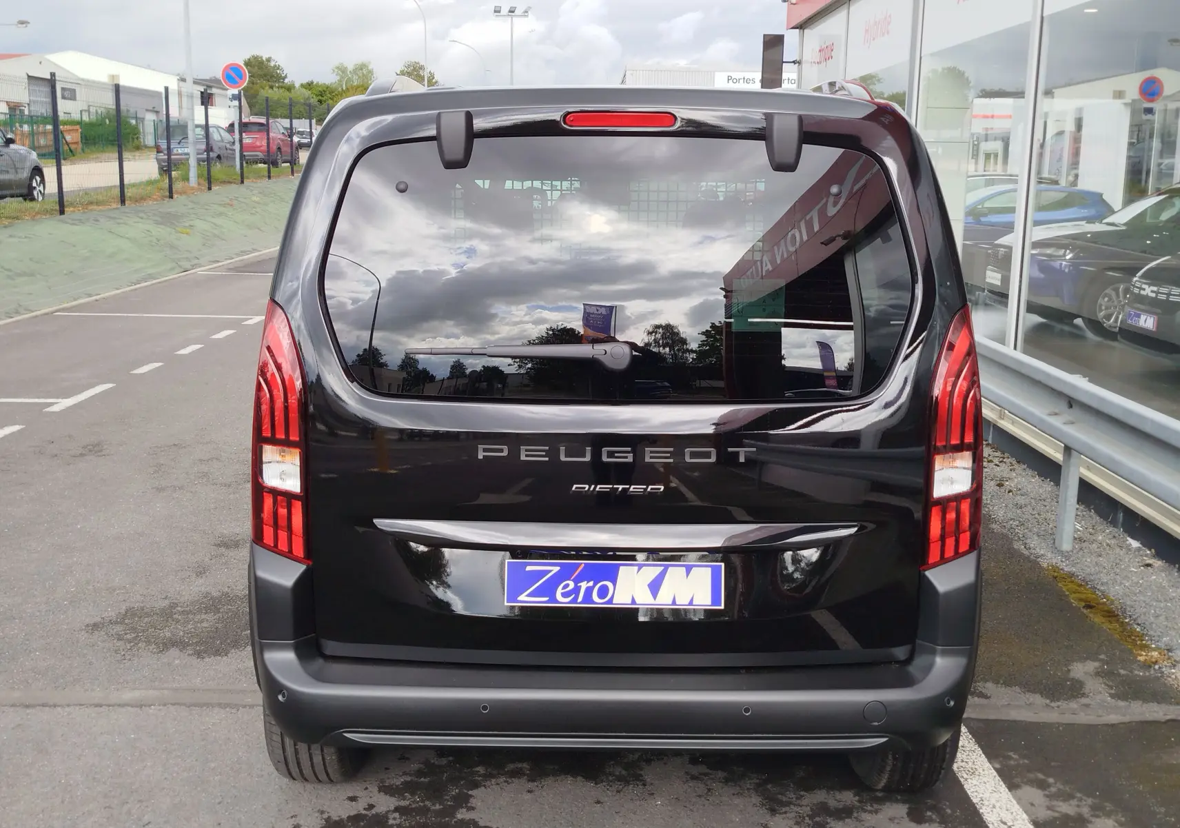 Vue arrière d'un Peugeot Rifter noir Perla Nera 2026 avec feux verticaux et plaque d'immatriculation Zéro KM.