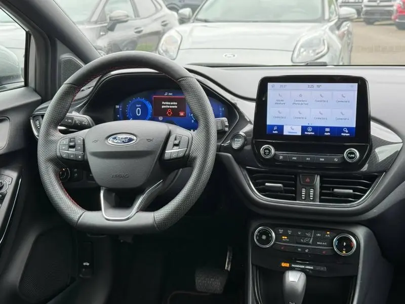 Vue intérieure du tableau de bord et volant noir du Ford Puma 2024, avec écran tactile central et affichage numérique.