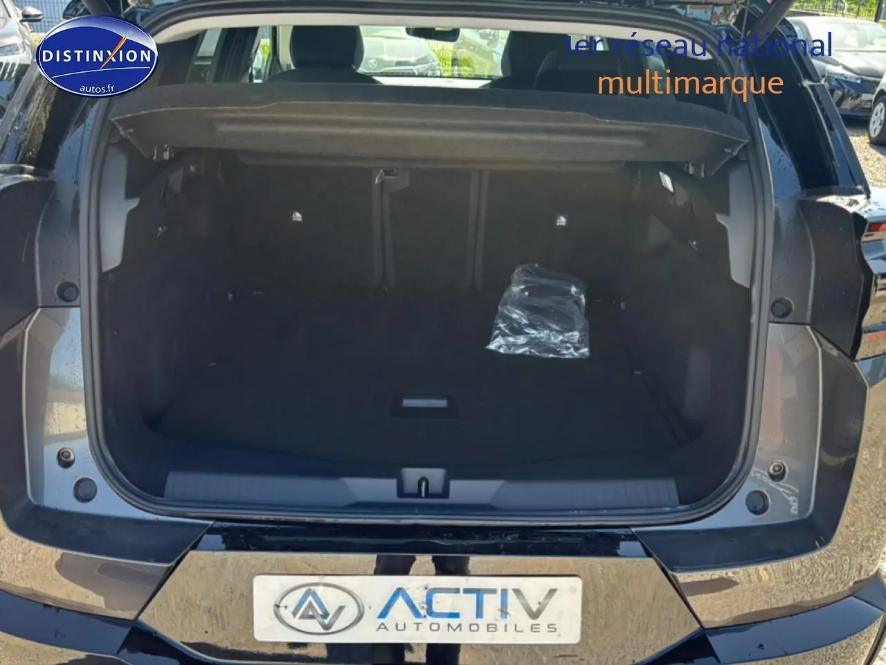 Coffre ouvert vu de l'arrière d'un Citroën C5 Aircross gris platinium avec hayon électrique et plancher de coffre mobile.