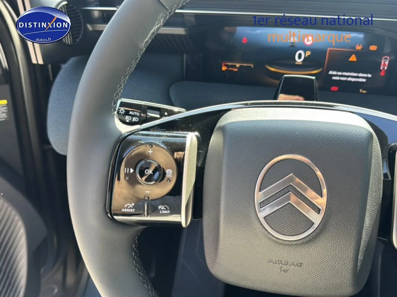 Gros plan sur le volant noir du Citroën C5 Aircross avec commandes multifonctions et logo chrome au centre.