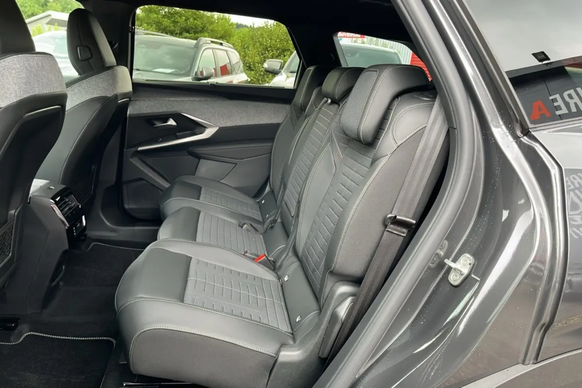 Vue côté droit sur la banquette arrière en cuir et tissu gris du Peugeot 5008 Hybrid 145 avec porte ouverte.