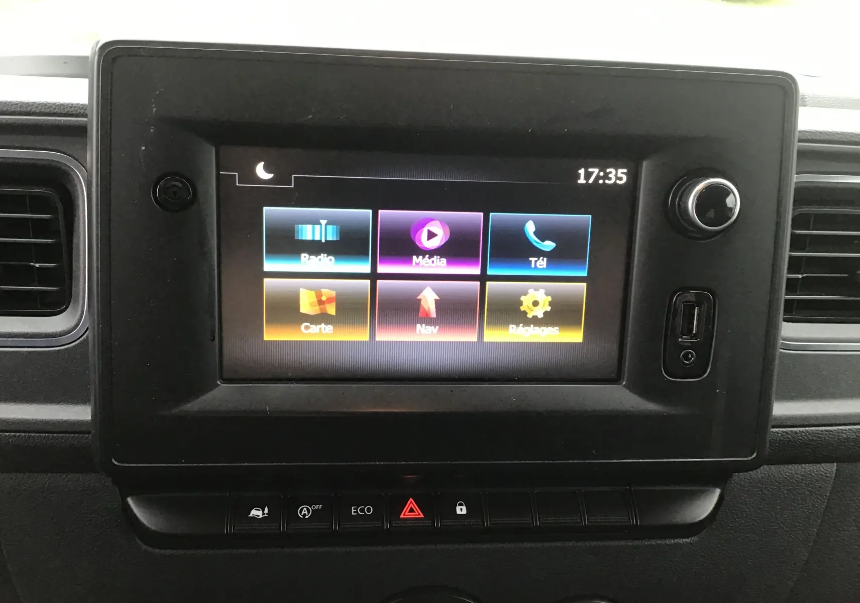 Écran tactile central du tableau de bord de l'Opel Movano blanc, affichant les options multimédia et navigation.