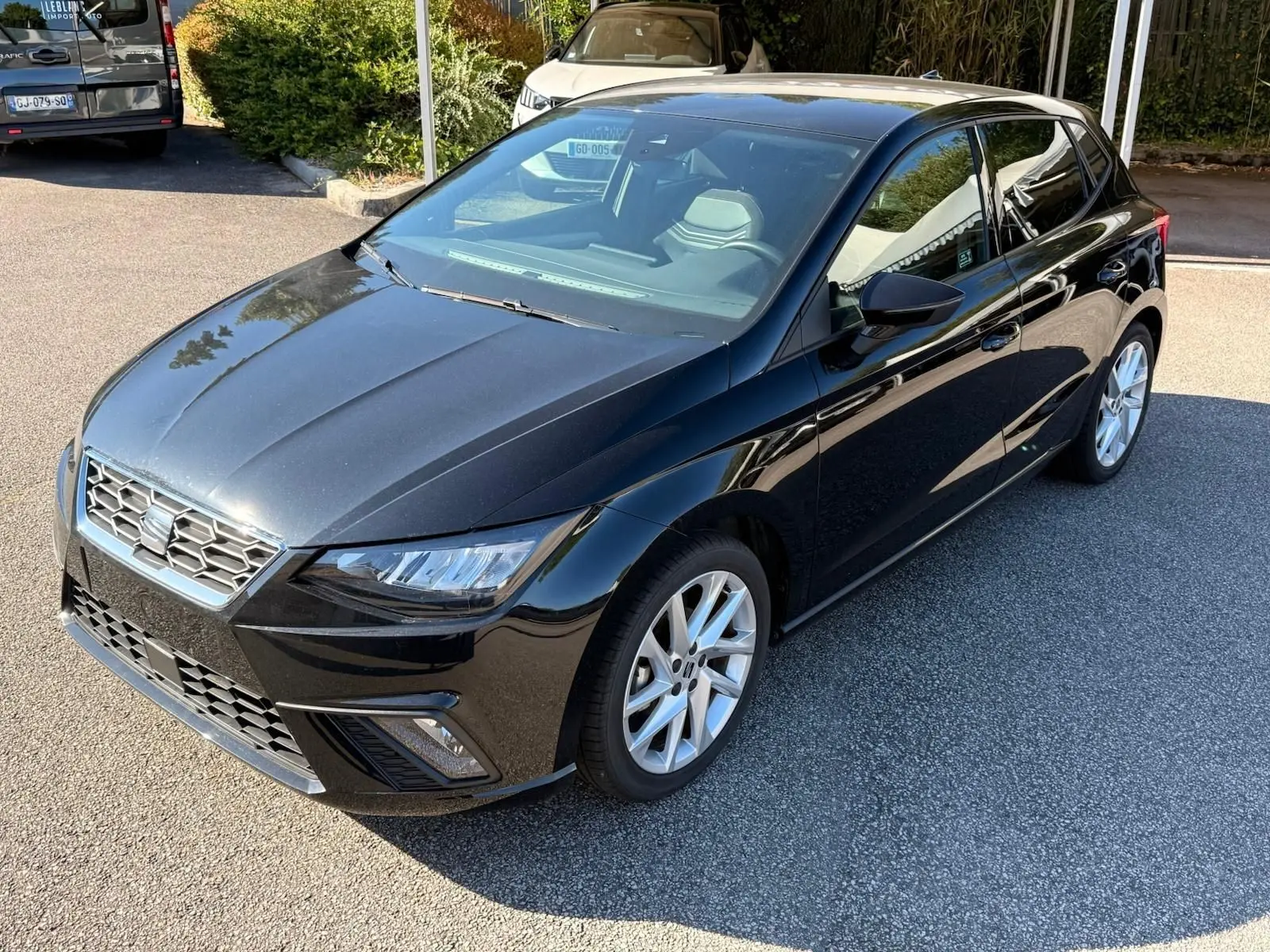SEAT Ibiza 1.0 TSI 95 FR noire vue en 3/4 avant droit, avec jantes argentées et phares LED distinctifs.