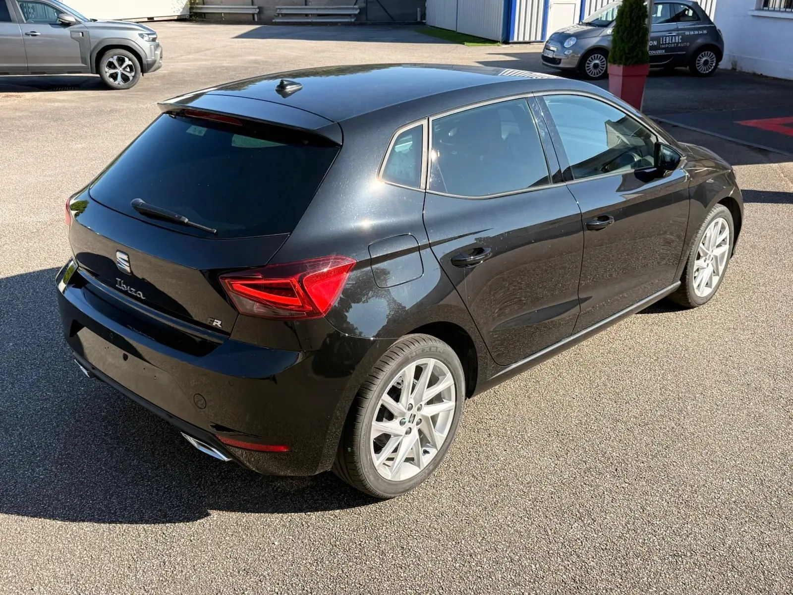 Vue 3/4 arrière droite de la SEAT Ibiza noire 2025 avec jantes alliage et feux arrière LED distinctifs.